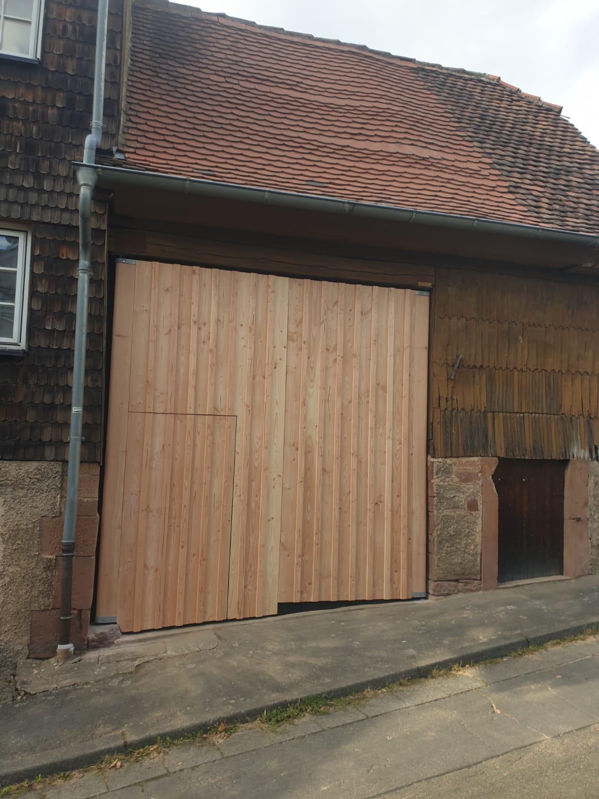 Grange rénovée avec nouveau bardage en bois douglas et porte coulissante neuve